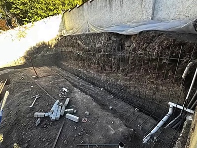 Excavated slope with rebar and drain lines during pool site grading in La Verne, CA