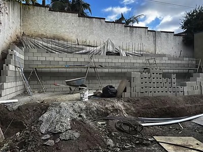 Masonry block wall under construction beside the pool excavation in La Verne