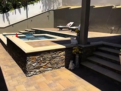 Finished La Verne pool with a raised stacked-stone spa, steps and paver deck