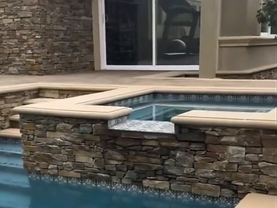 Raised spa corner with stacked stone and paver deck by the sliding doors in La Verne