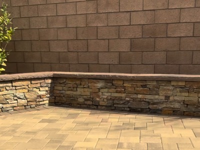 Multi-tone paver patio with a stacked stone seat wall in a Fontana, CA backyard