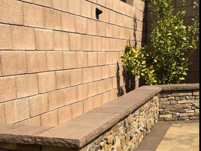 Stacked stone seat wall with a flagstone cap meeting the paver patio in Fontana, CA