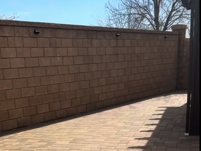 Paver surface with clean edges and precision cuts along a backyard wall in Fontana, CA